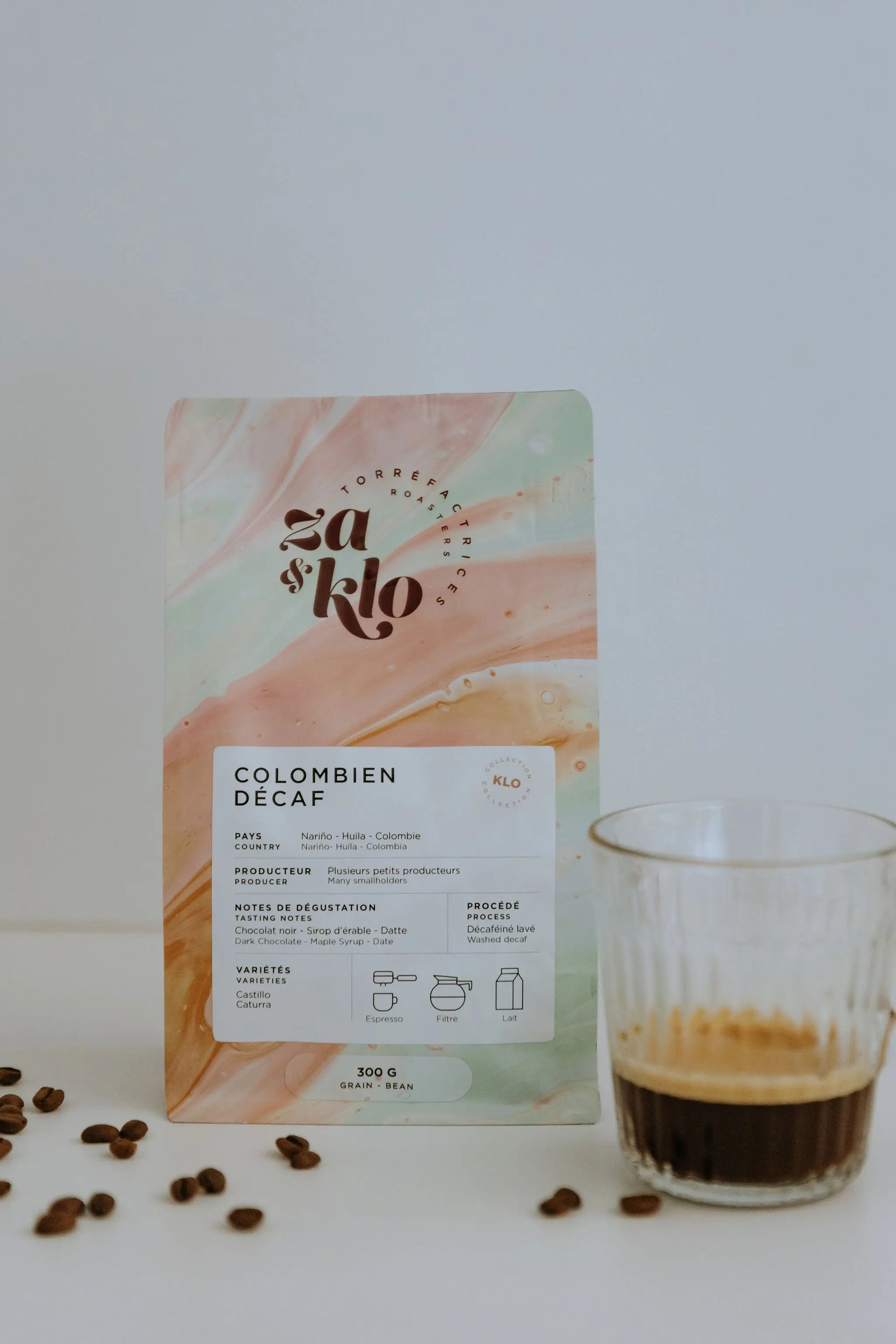 Image d’un sac de café illustrant un décaféiné provenant de plusieurs petites fermes d’une même communauté en Colombie. Le sac met en avant des notes de datte, chocolat et sirop d’érable, avec une typographie visible affichant le nom du café. Ce décaféiné délicieux et versatile se déguste en pour over, en espresso ou mélangé avec du lait, offrant une expérience gourmande comparable à un café classique. Za et Klo Torrefaction.