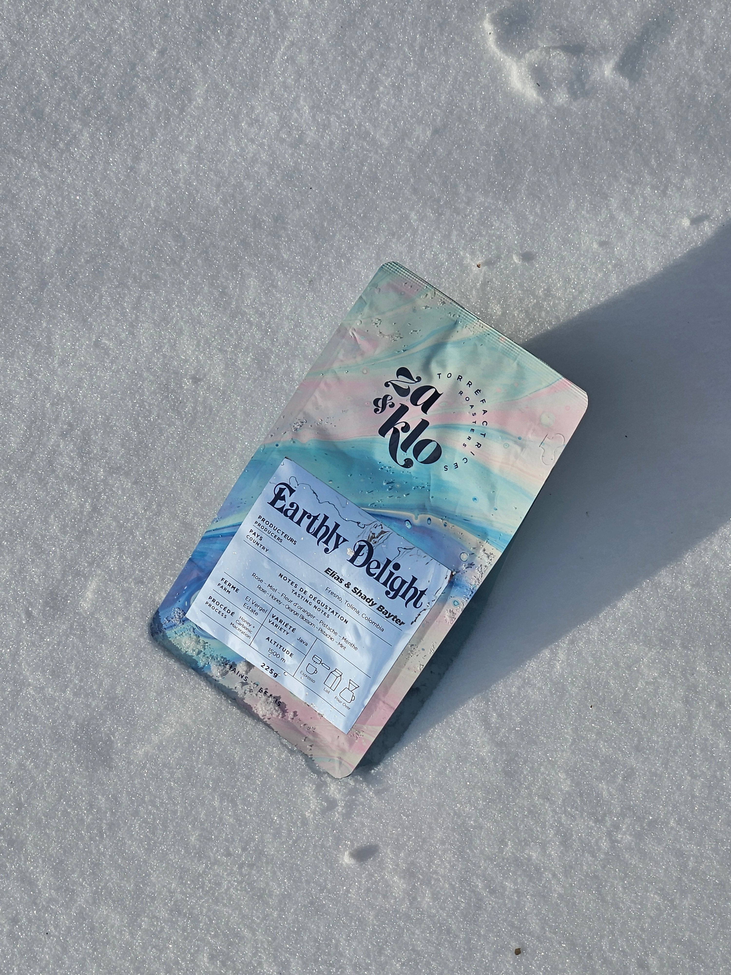 Image of Za & Klo coffee bag with reflective label. Coffee has notes of rose, pistachio, honey and orange blossom. Za and Klo's coffee named earthly delight.