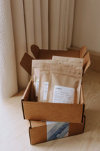 Photo, Boîte Découverte, avec une typographie visible affichant « Boîte Découverte ». Cette boîte personnalisable permet de découvrir nos cafés à votre façon, en choisissant 4 cafés de 150 g parmi notre sélection. Idéale pour offrir ou explorer différents profils de café, avec la possibilité de demander des suggestions aux torréfactrices.